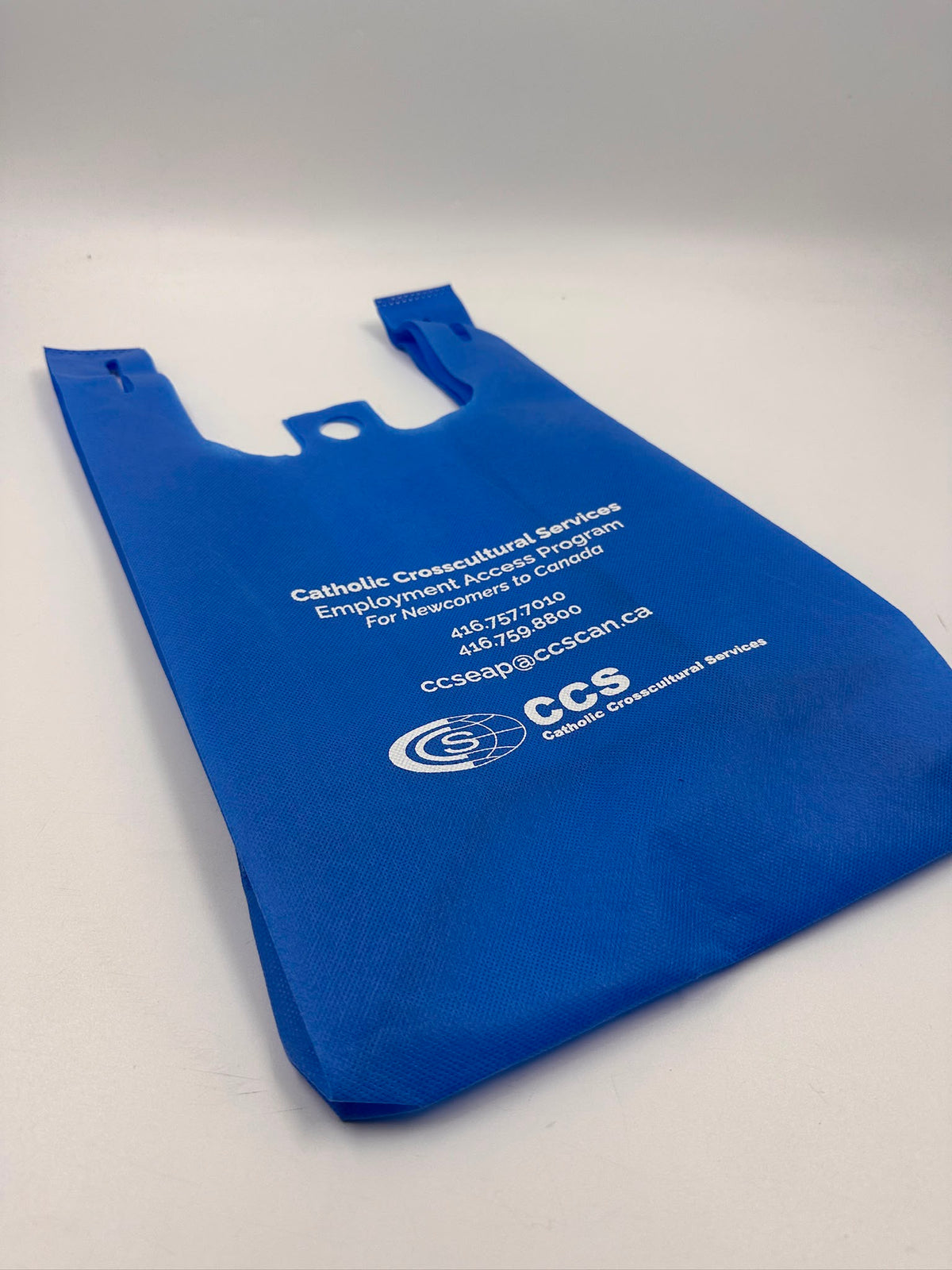 White logo and text screen printed on a blue promotional bag
