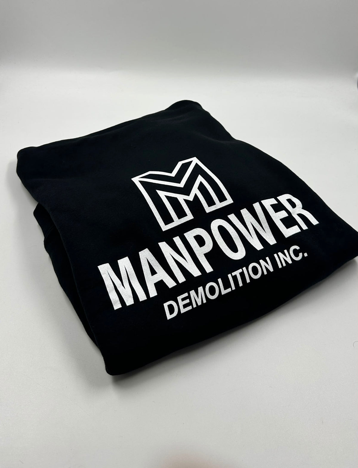 White company logo screen printed on black apparel